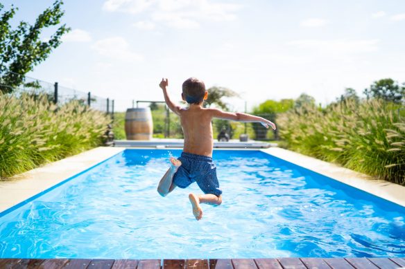 Junge springt in einen Swimming Pool